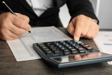 man using calculator to cross verify the records