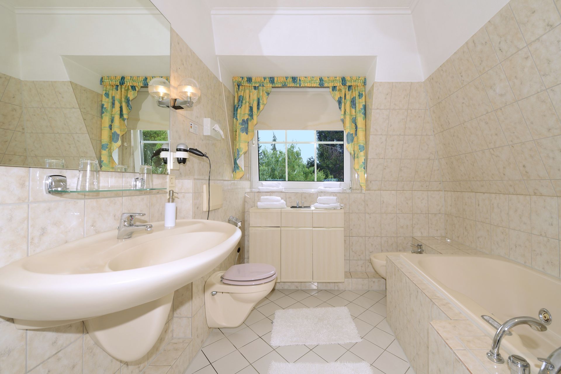 Ein Badezimmer mit Waschbecken, Toilette, Badewanne und Spiegel