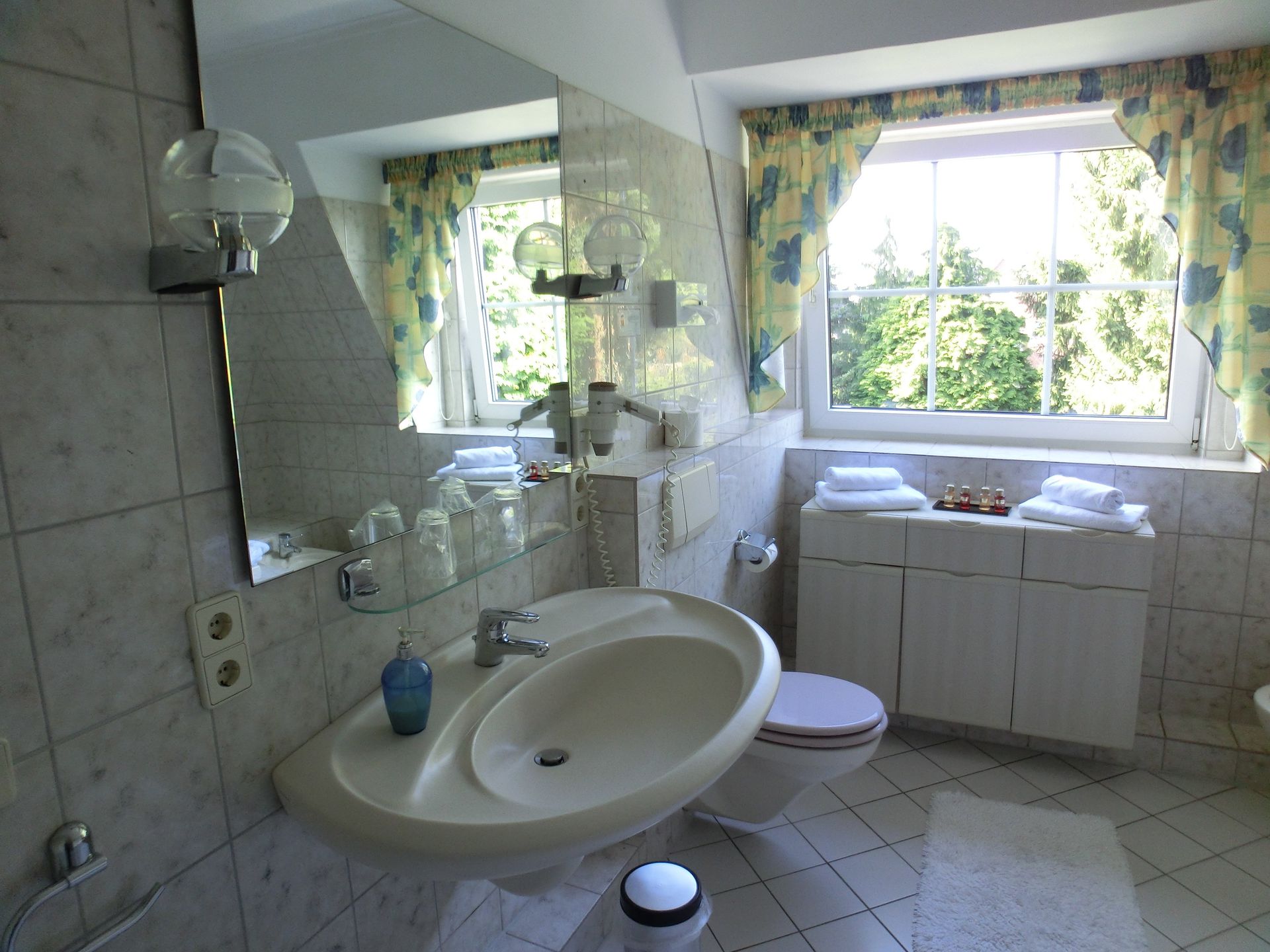 Ein Badezimmer mit Waschbecken, Toilette und Fenster