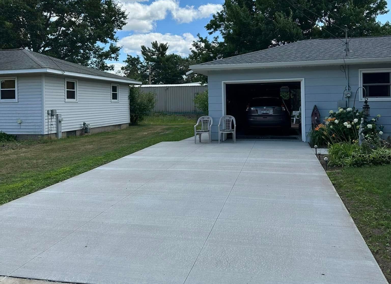 A car is parked in a garage next to a house.