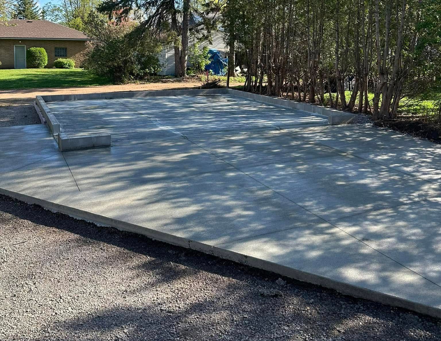 A concrete driveway is being built in front of a house.