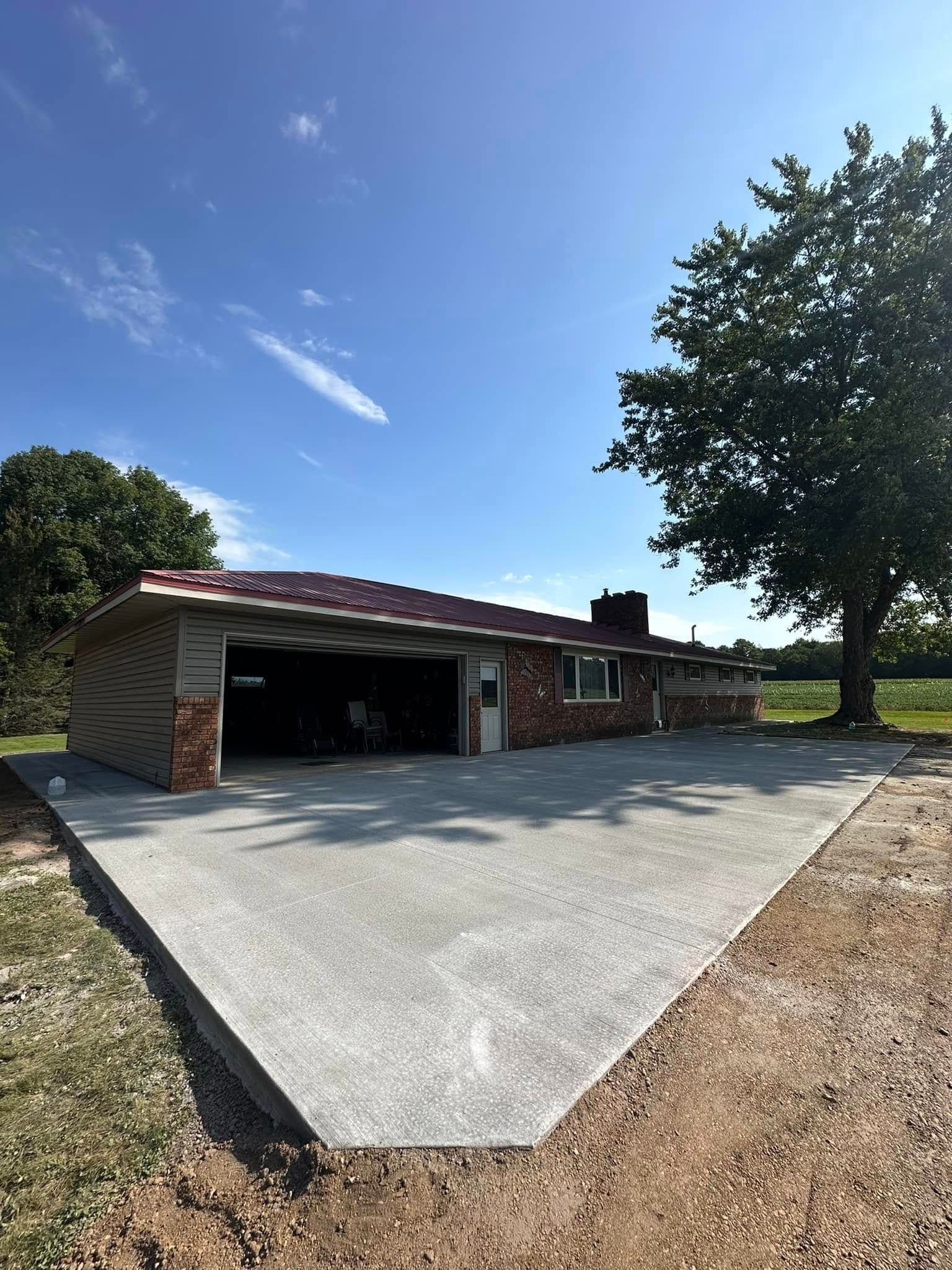 A house with a garage and a concrete driveway in front of it.