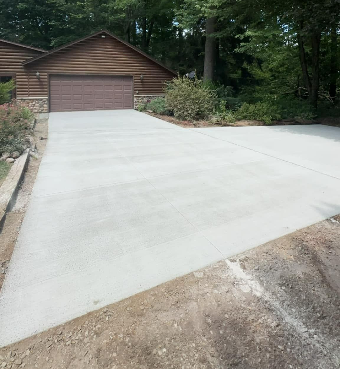 A concrete driveway leading to a house with a garage door