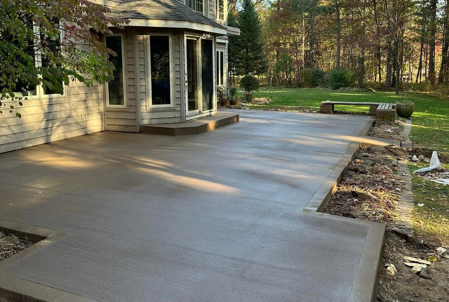 A concrete patio is being built in front of a house.