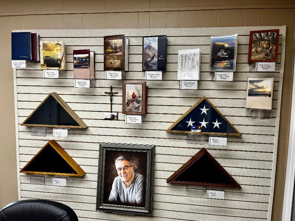 Display of memorial urns, flag cases, and a portrait on a pegboard wall.