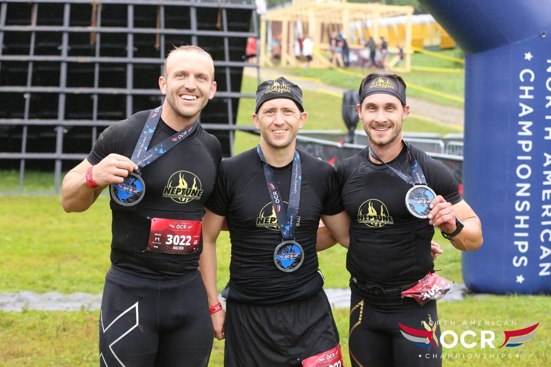 Three men are posing for a picture while wearing medals.