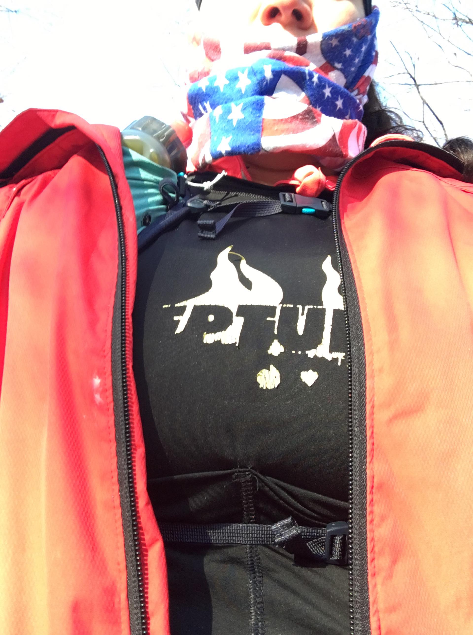 A woman wearing a red jacket and a black shirt with the word tribe on it