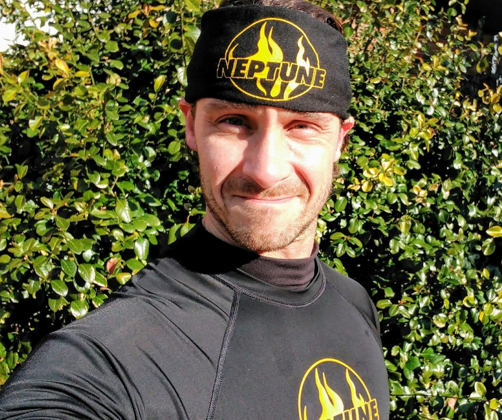 A man wearing a headband with the word neptune on it