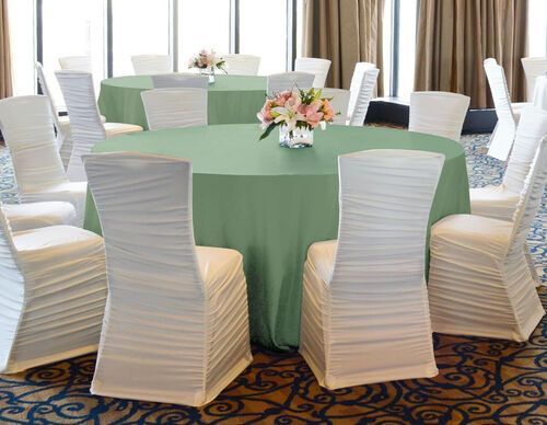 A round table with a white tablecloth and black legs on a white background.