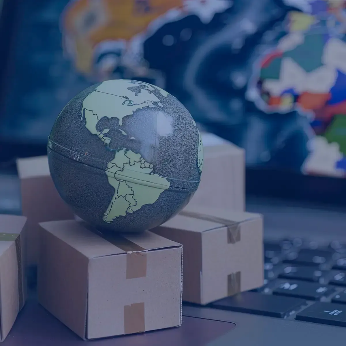 A small globe is sitting on top of a pile of cardboard boxes.