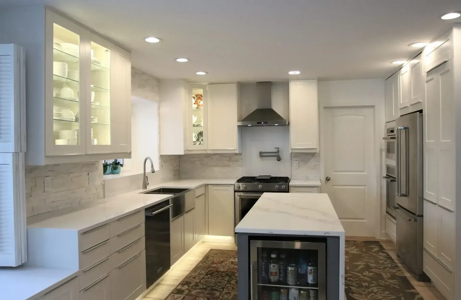 Bright white modern kitchen with island, stainless appliances, and patterned runner rug