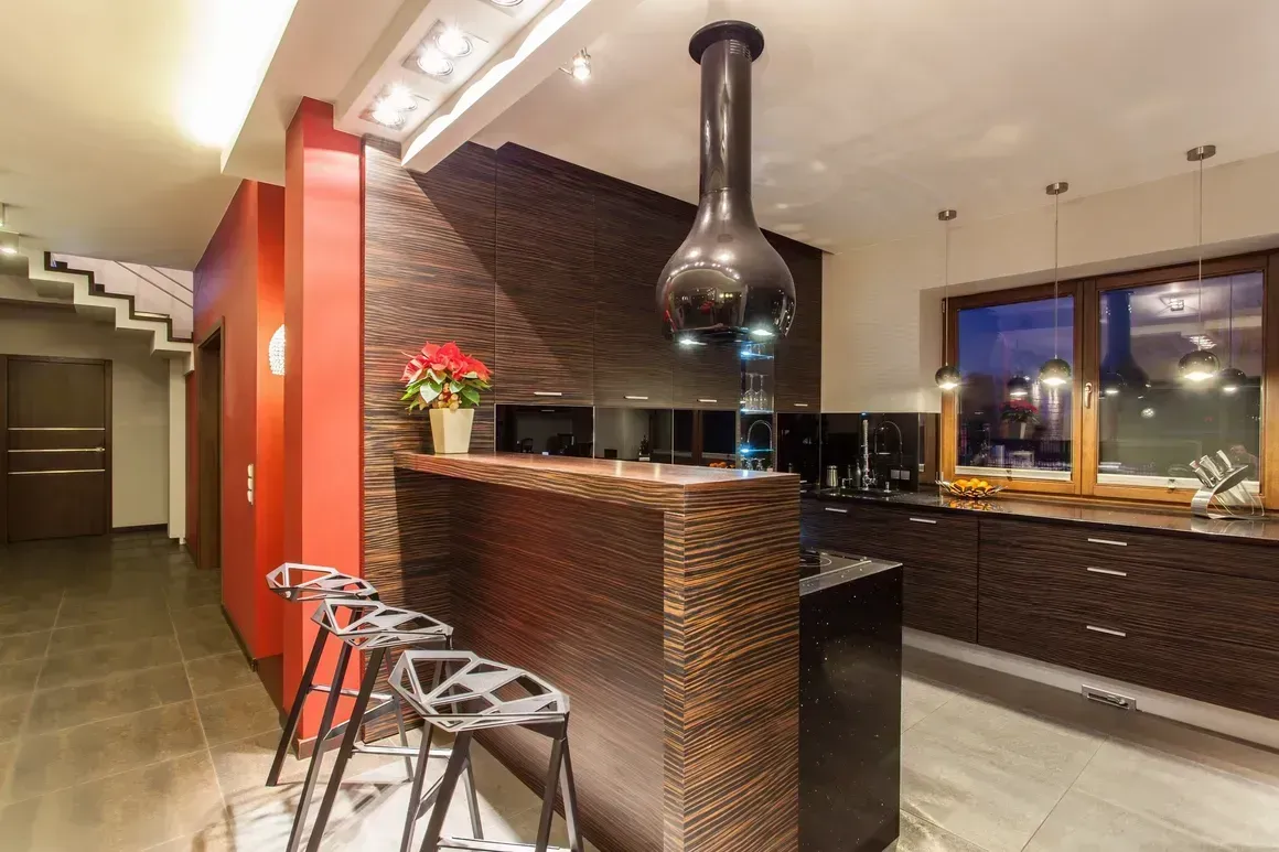 Modern bar interior with wicker counter, red accent wall, stools, and pendant lighting