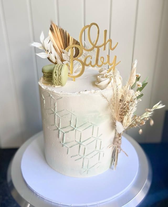A white cake with a gold topper is sitting on top of a white plate.
