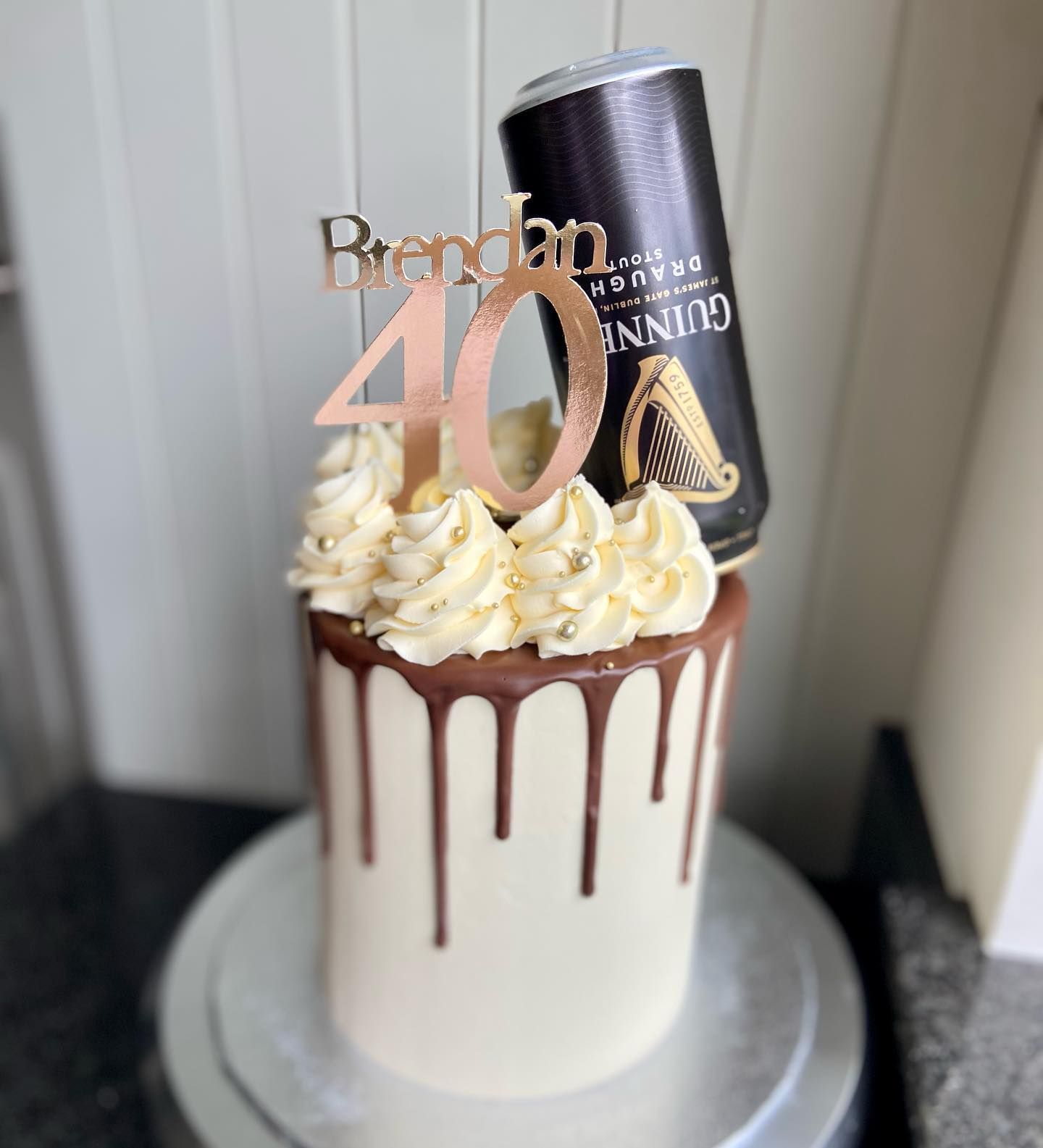 A 40th birthday cake with a can of guinness on top.