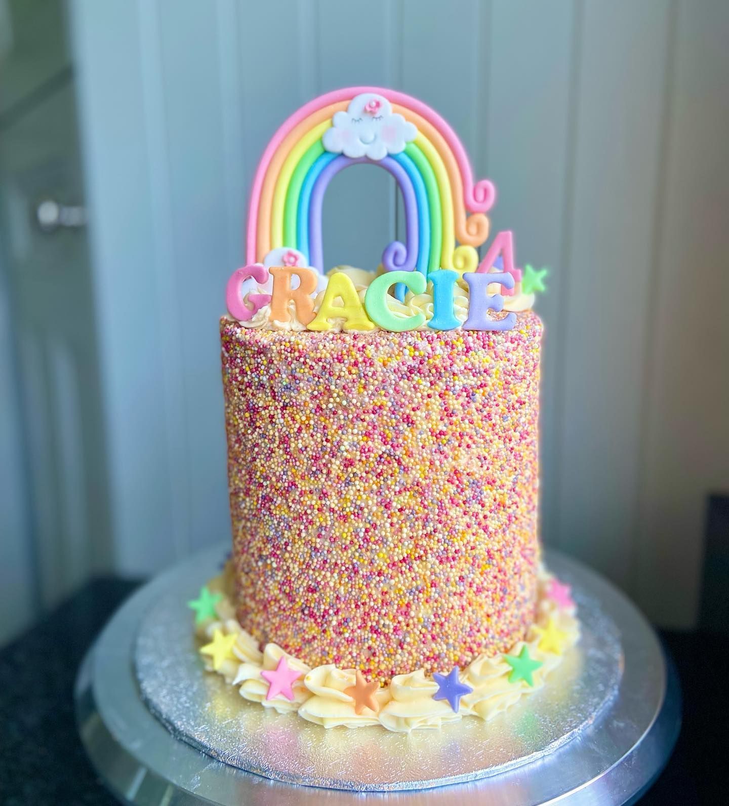 A birthday cake with a rainbow and the name gracie on it.