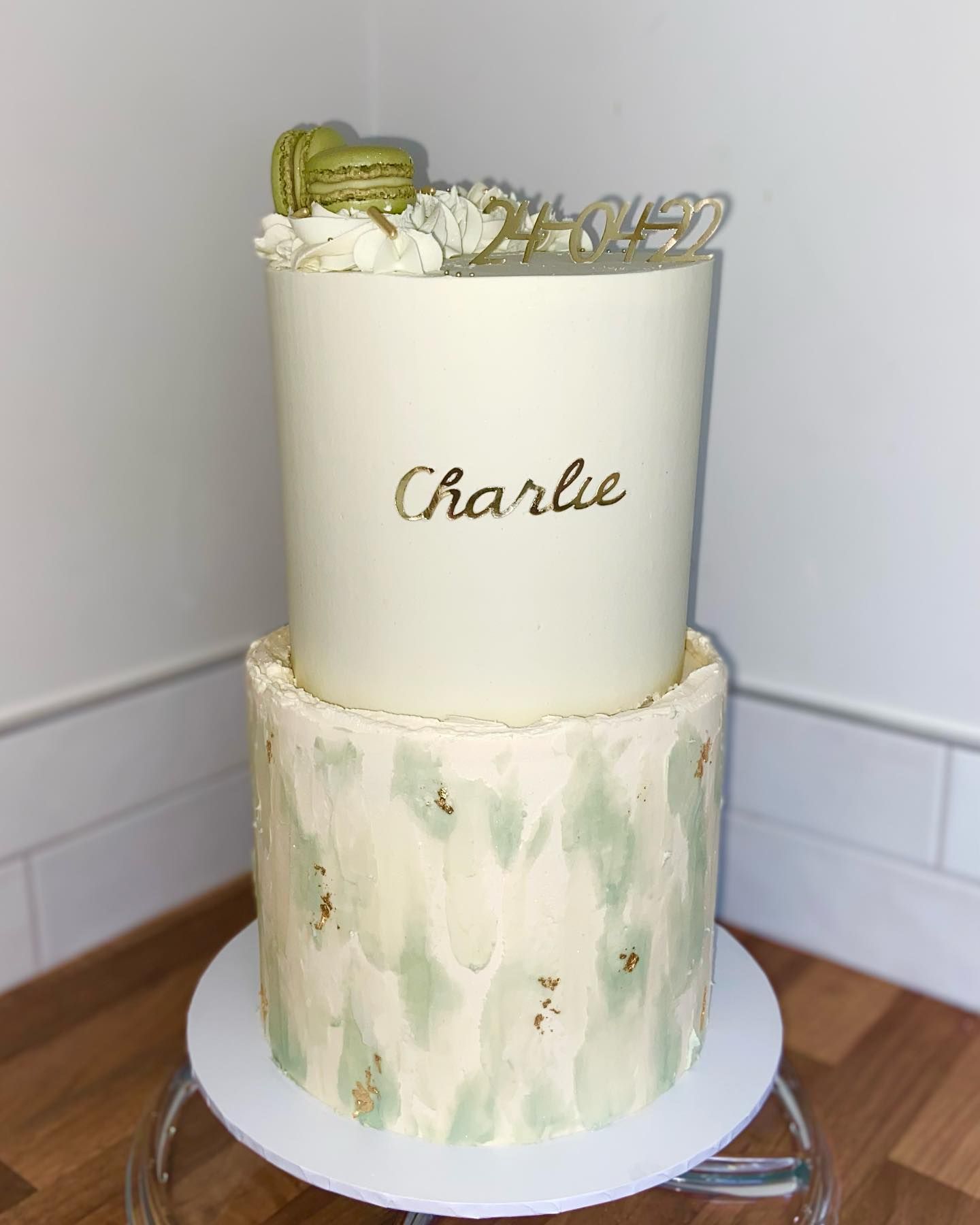 A white cake with the name charlie on it is sitting on a table.