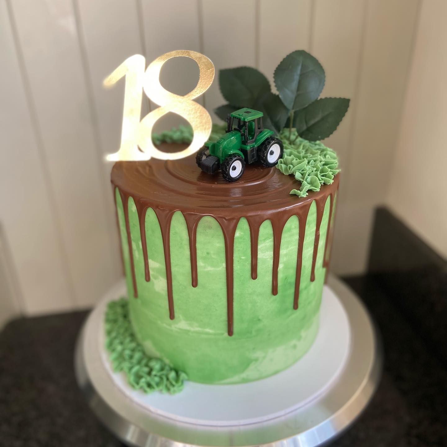 A green cake with the number 18 on top