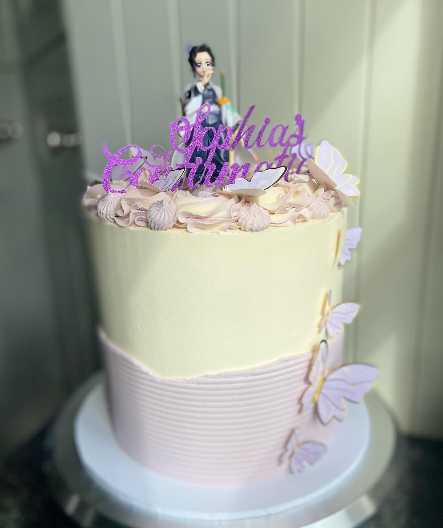 A birthday cake with a figurine on top of it is sitting on top of a cake stand.