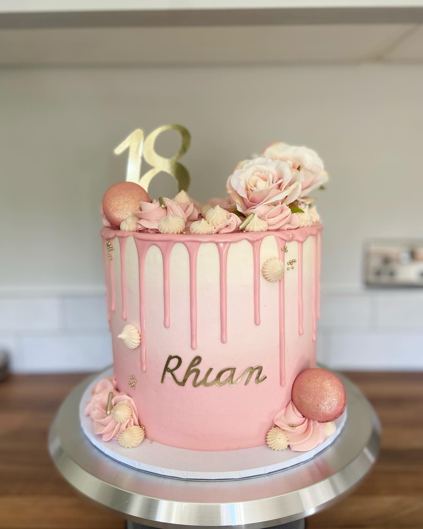 A pink drip cake with the name rhian on it