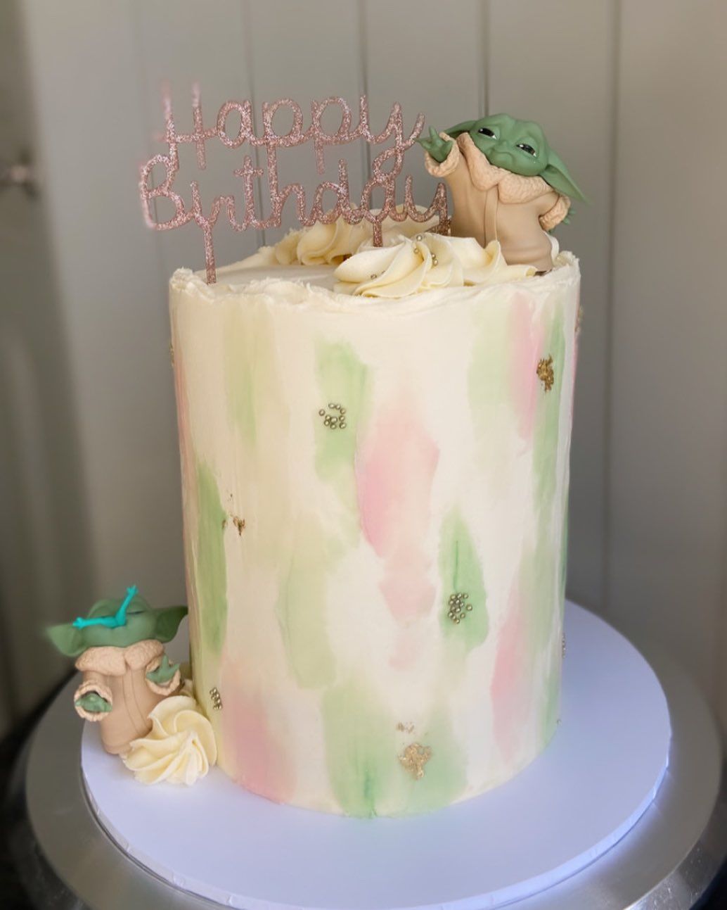 A birthday cake with a baby yoda on top of it.