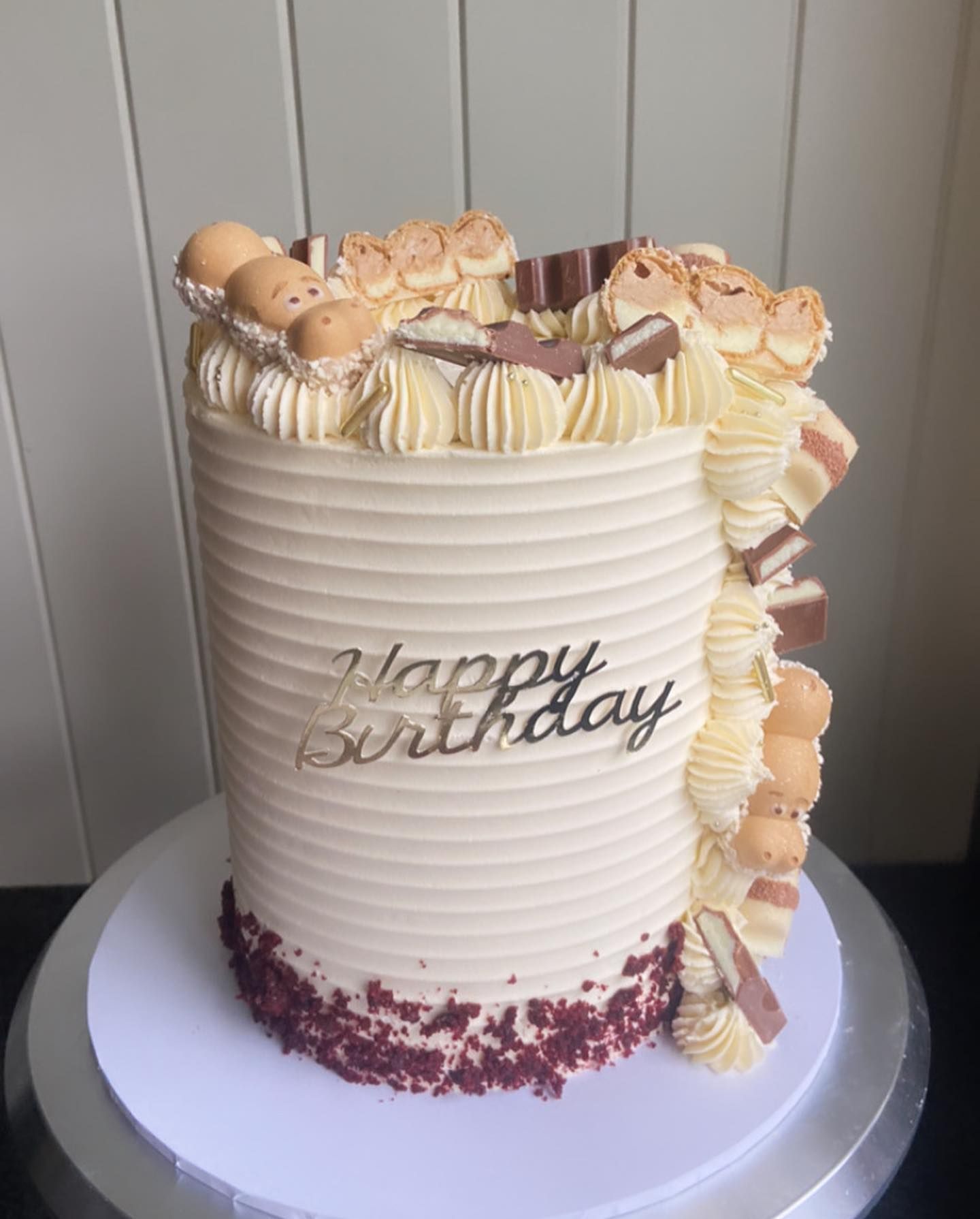 A birthday cake is sitting on top of a white plate on a table.