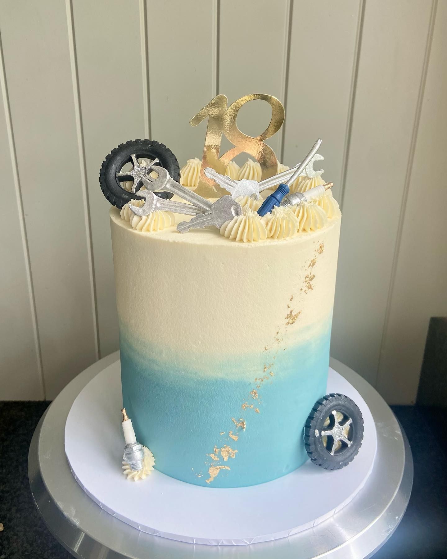 A blue and white cake with a motorcycle on top of it.
