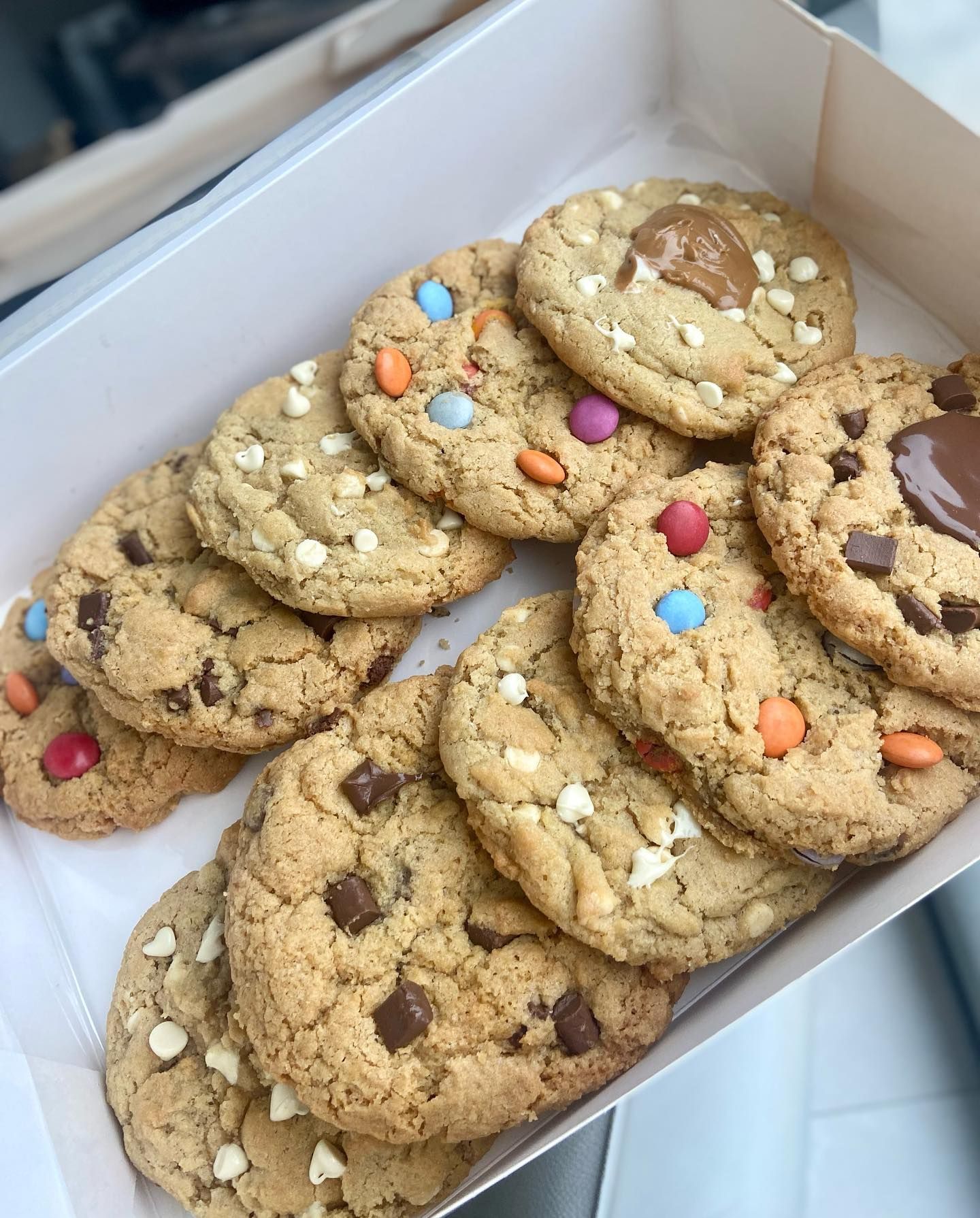 A box of cookies with chocolate chips and sprinkles on them.