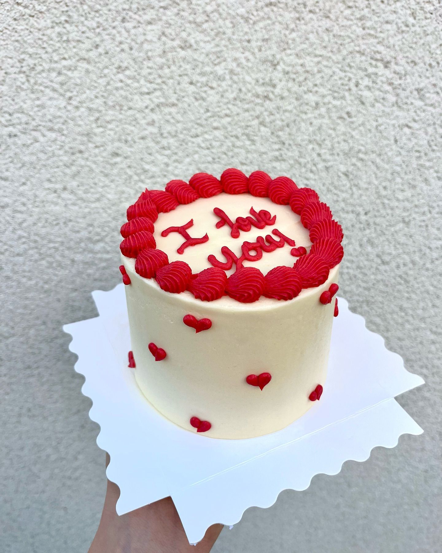 A person is holding a cake that says i love you