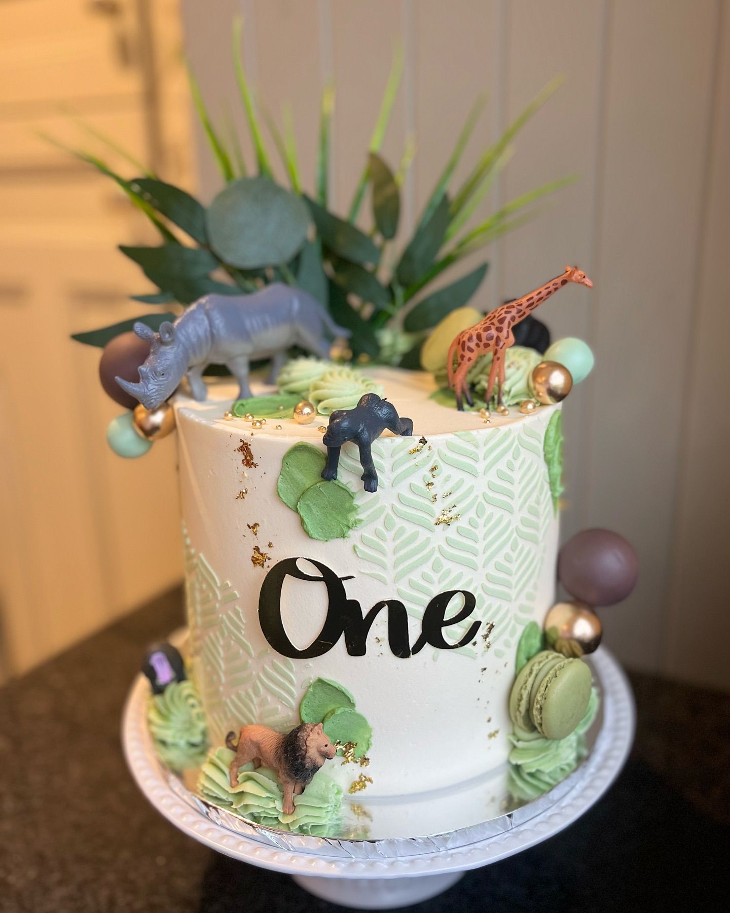 A cake with a rhino and a giraffe on top of it.