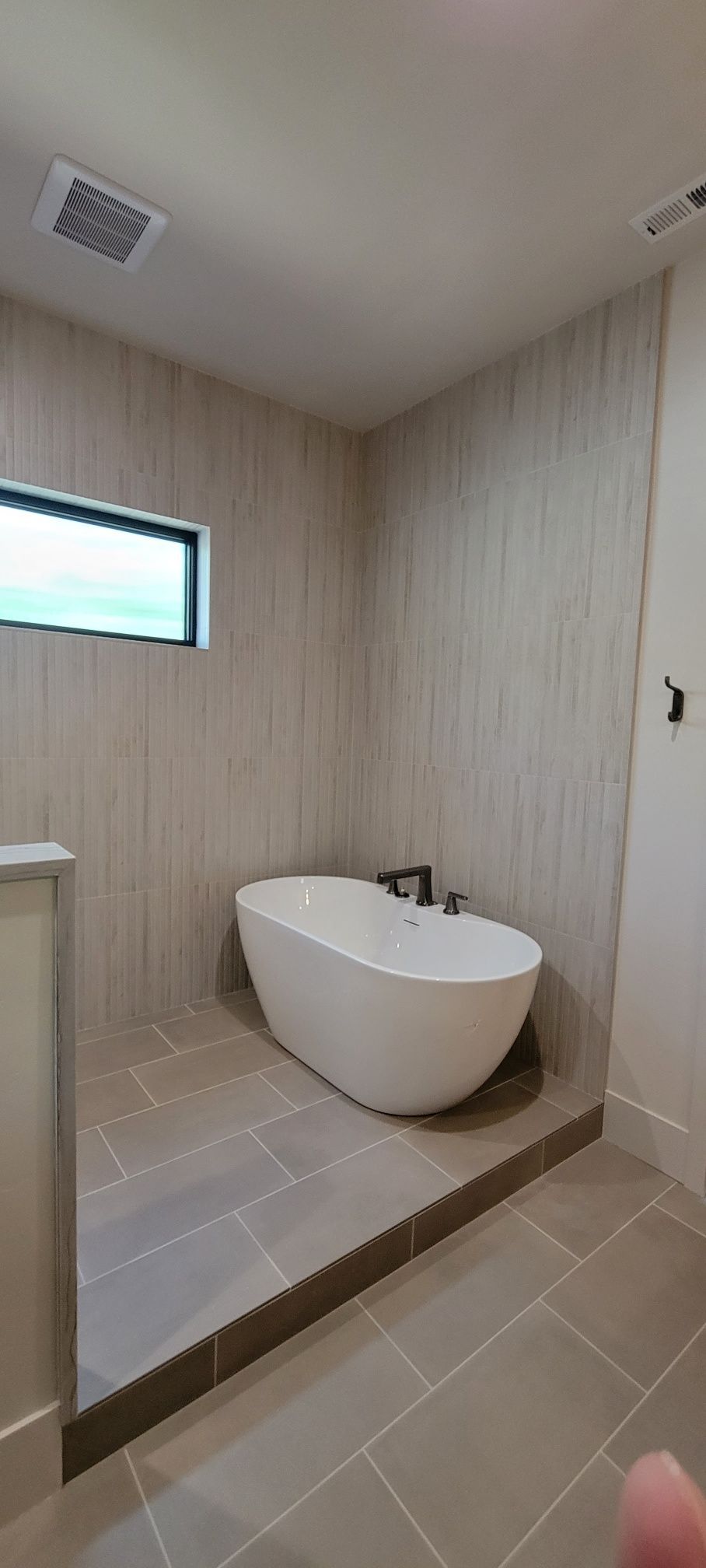 A bathroom with a bathtub and a window.