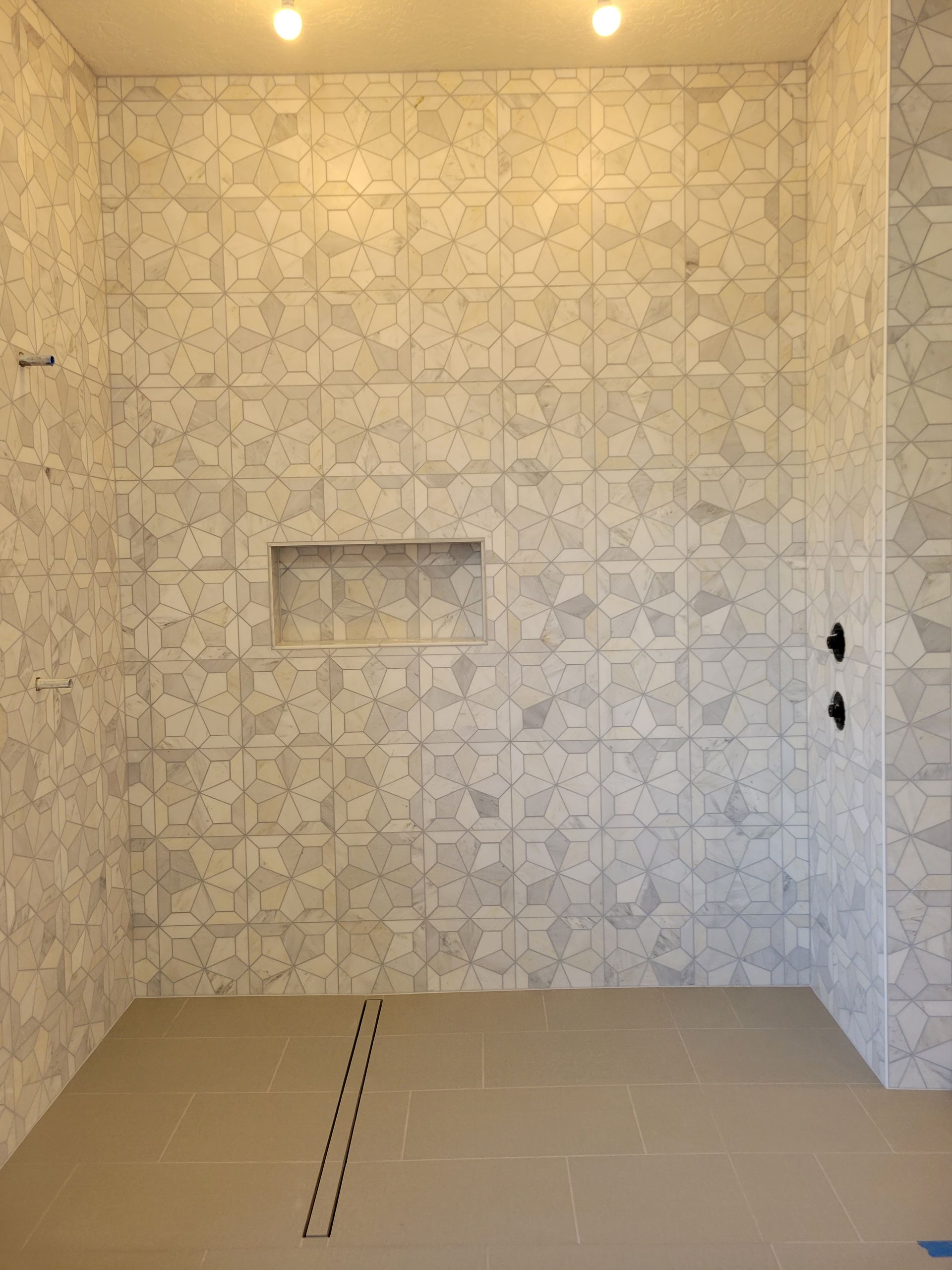 A bathroom with a brick wall and a tiled floor.