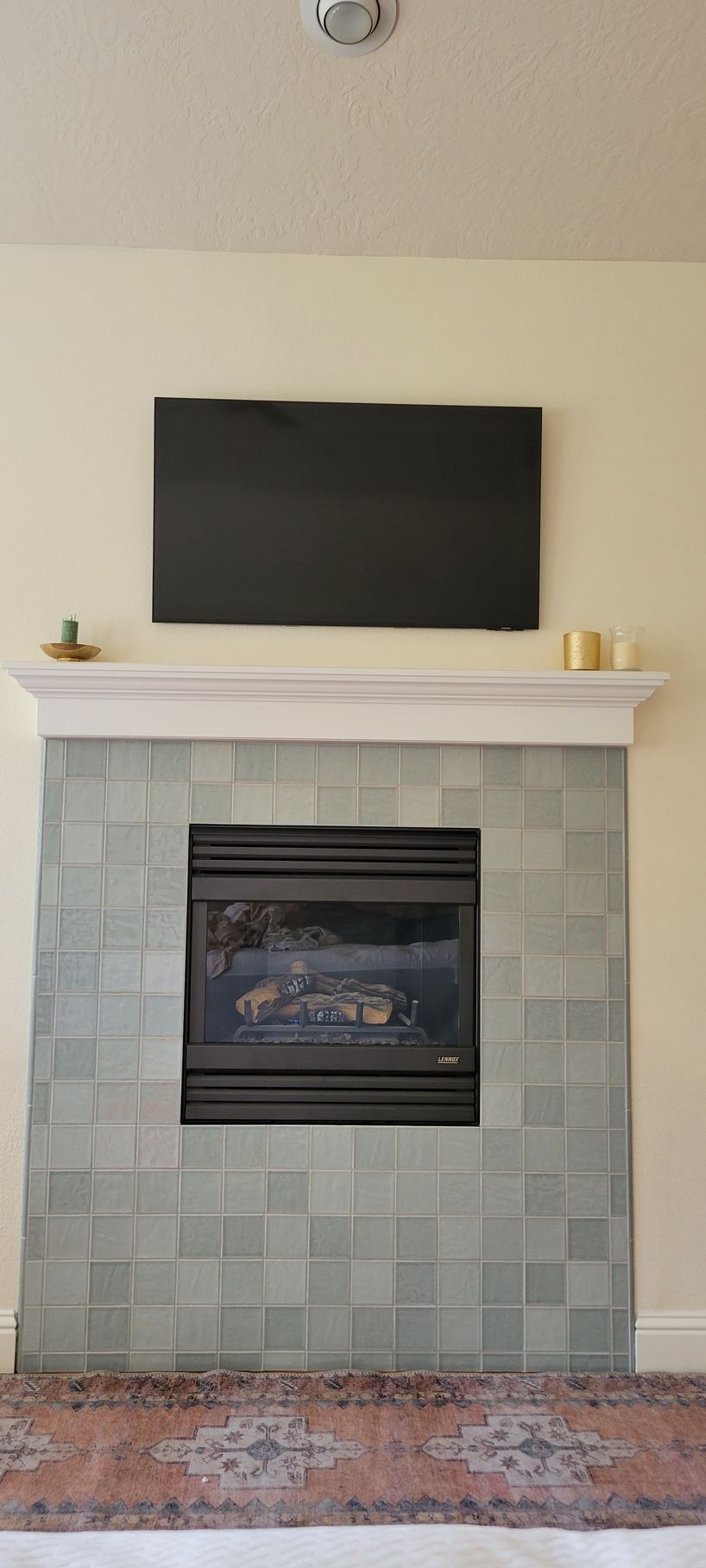 A living room with a fireplace and a flat screen tv on the wall.