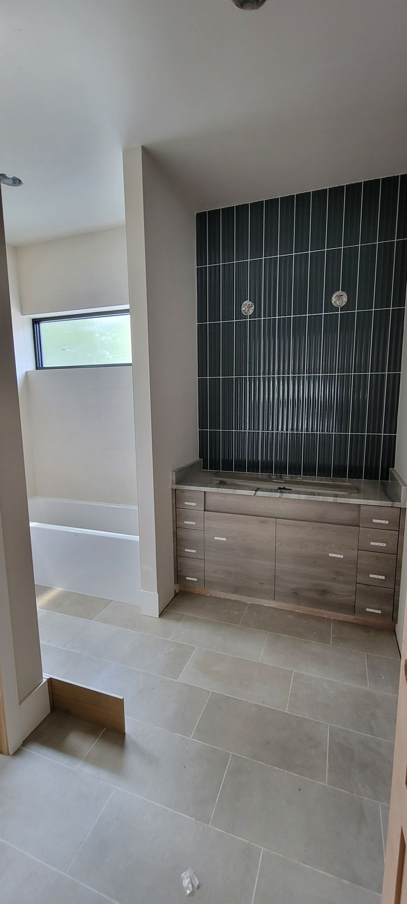 An empty bathroom with a sink and a window.