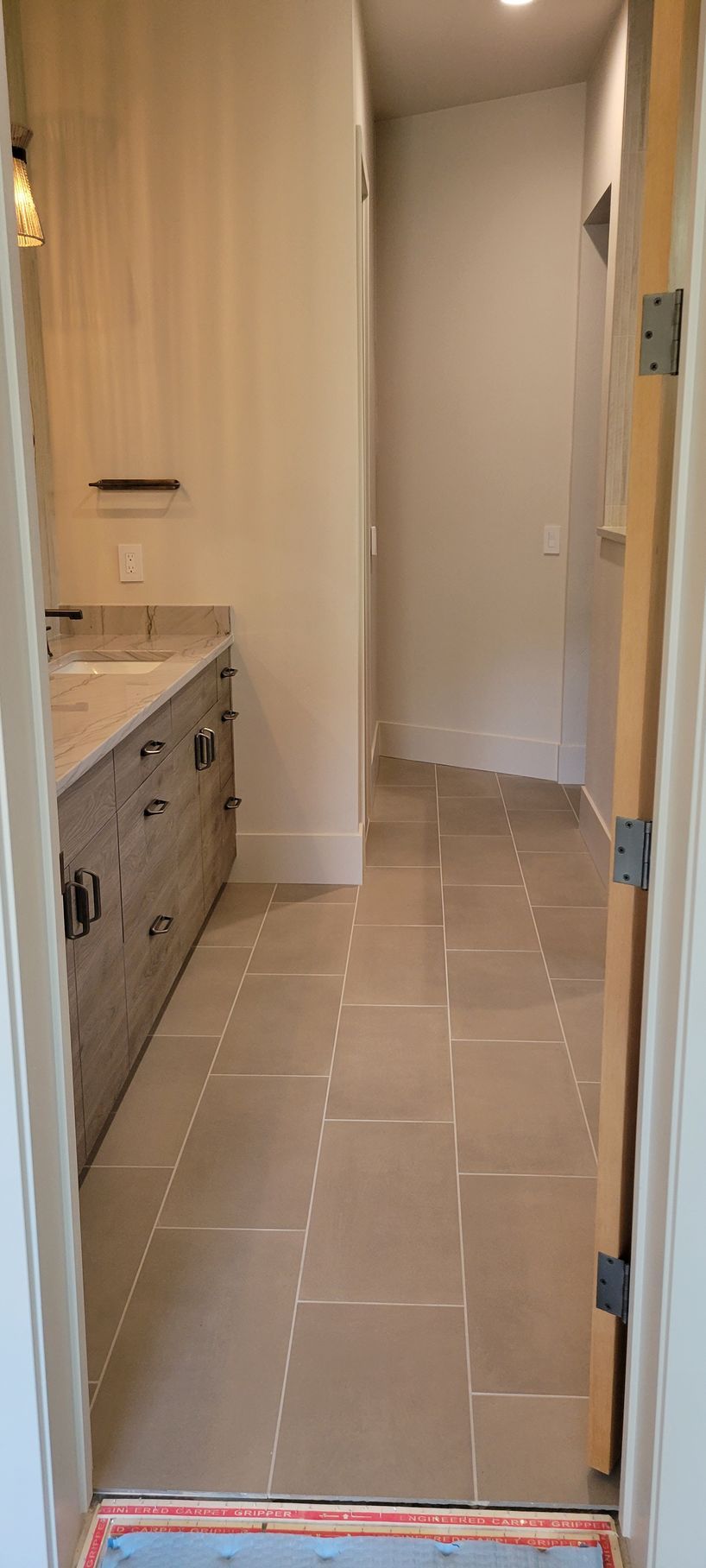 A bathroom with a sink and a door leading to a hallway.