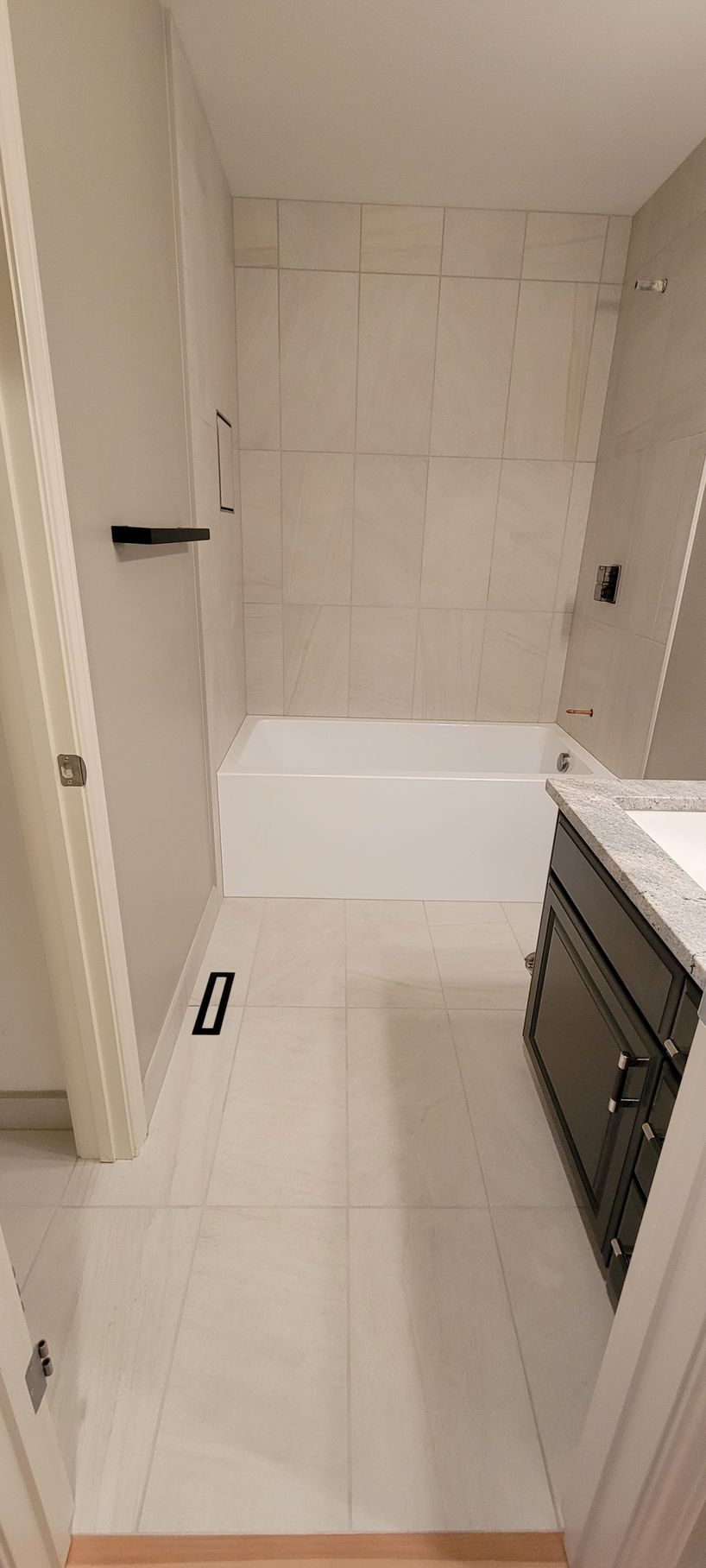 A bathroom with a bathtub , sink , and shower.