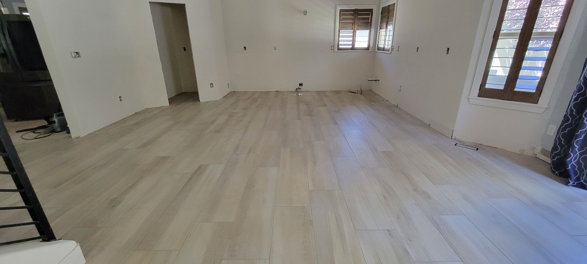 A large room with a wooden floor and white walls.