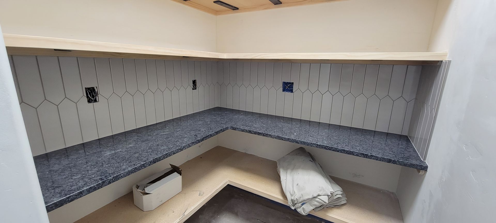 A corner of a room with a bench and shelves.