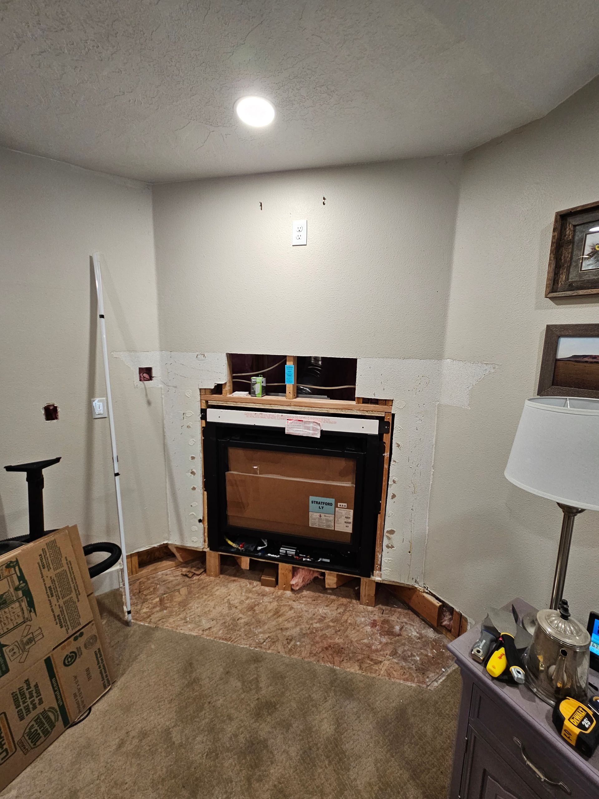 A living room with a fireplace being built into the wall.