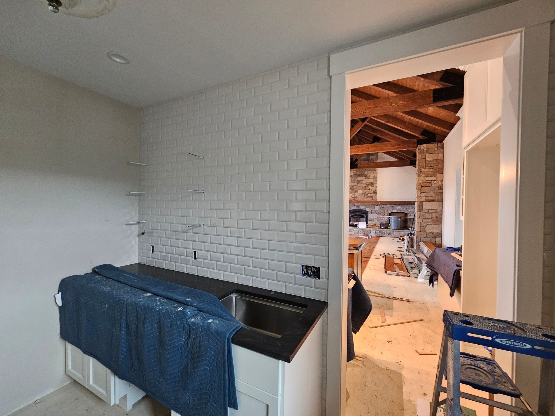 A kitchen with a sink and a ladder in it