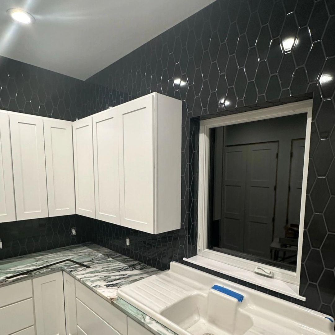 A kitchen with white cabinets and a sink and a window