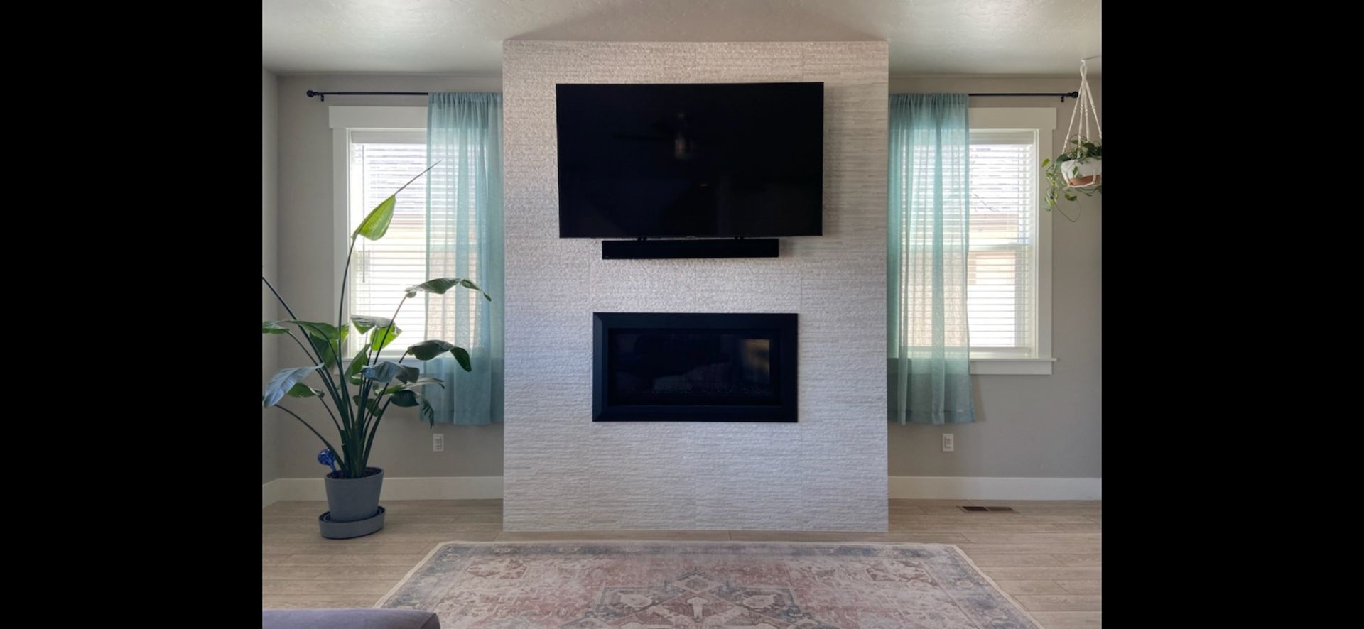 A living room with a fireplace and a flat screen tv mounted on the wall.