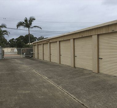 A row of garage doors with a palm tree in the background