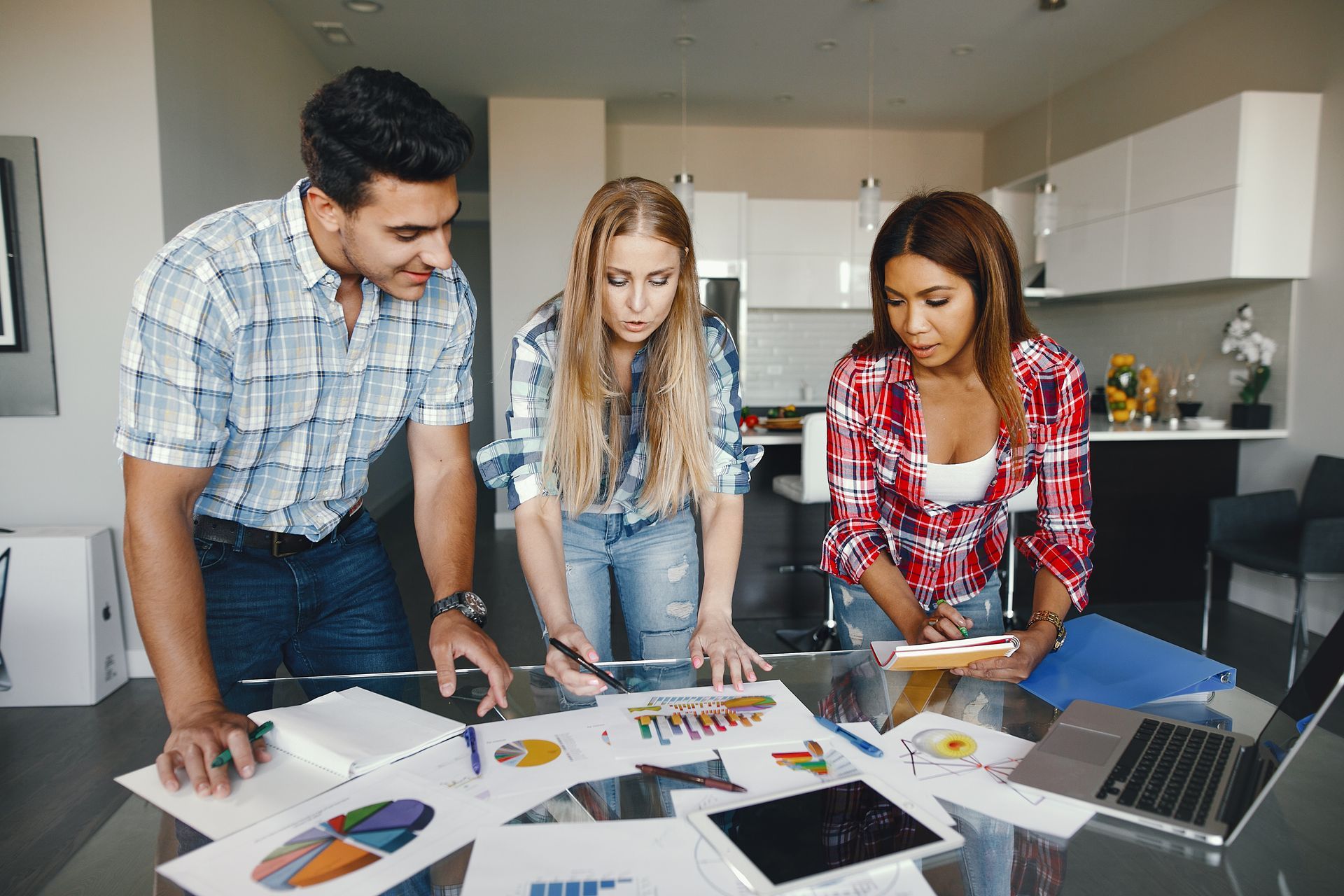 A group of people are standing around a table looking at papers.