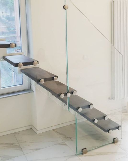 scala con gradini in acciaio e parapetto in vetro