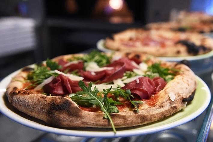 pizza con prosciutto crudo, rucola e scaglie di grana