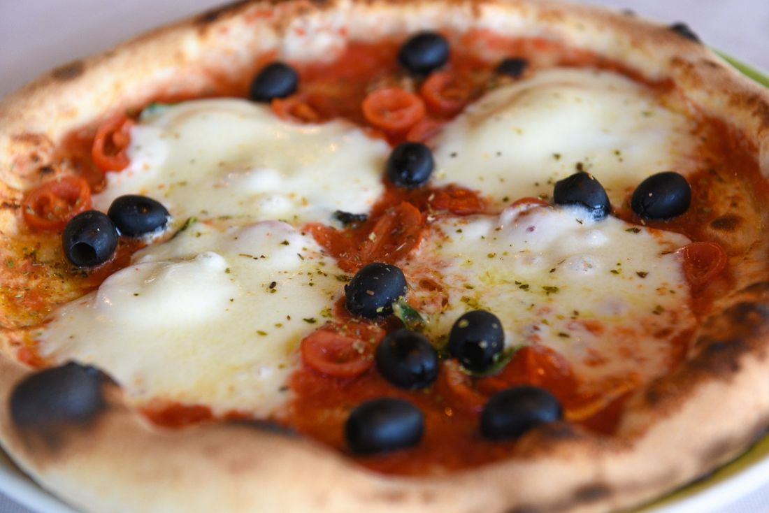 Pizza margherita con mozzarella, pomodorini e olive nere