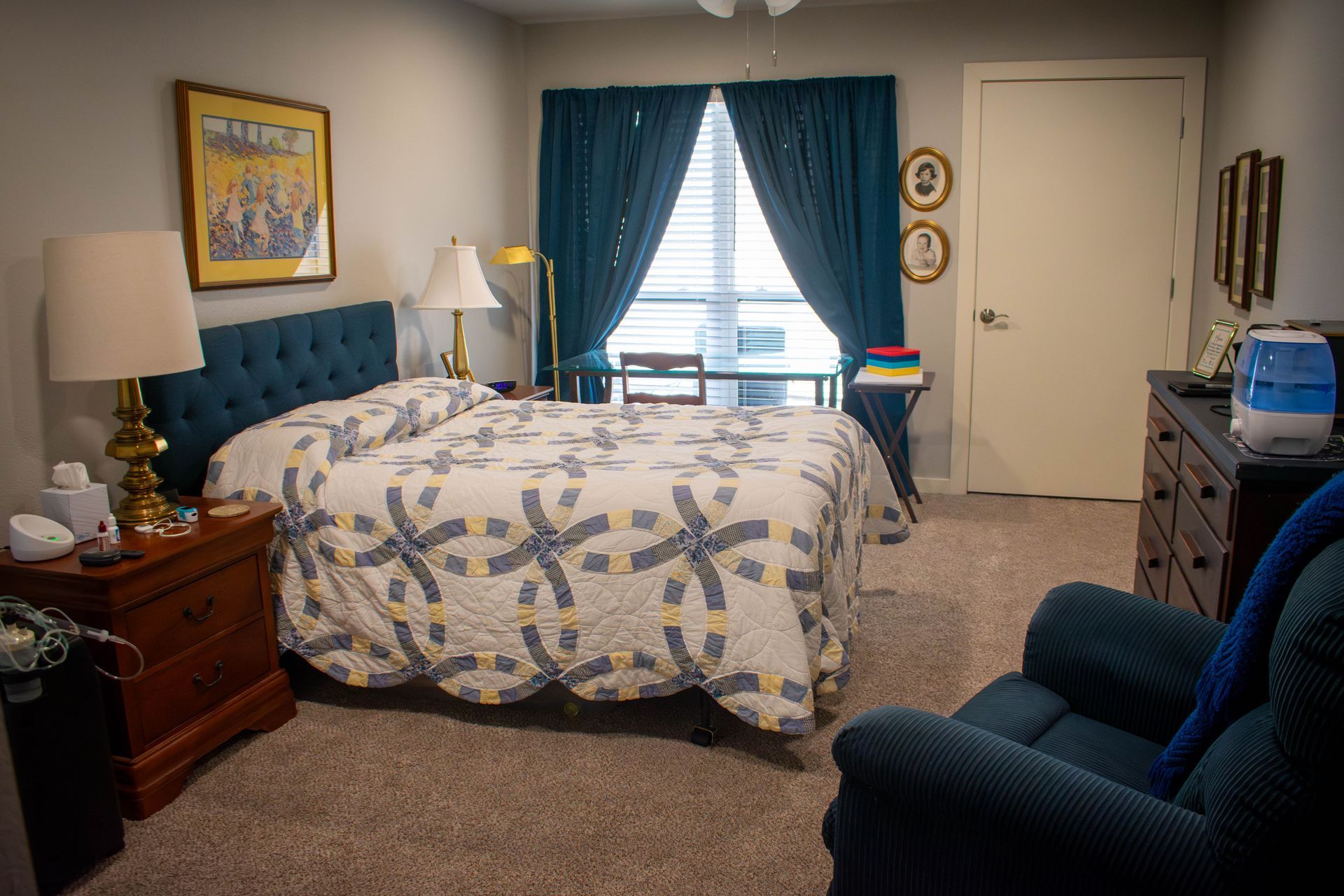 Bedroom with a bed, dresser, chair, and window with teal curtains.