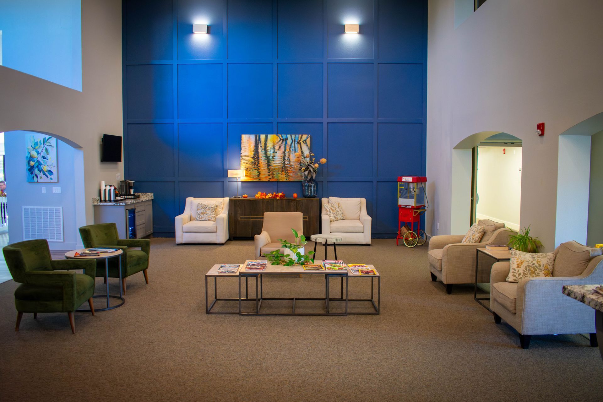 Spacious waiting area with blue accent wall, neutral sofas, and armchairs.