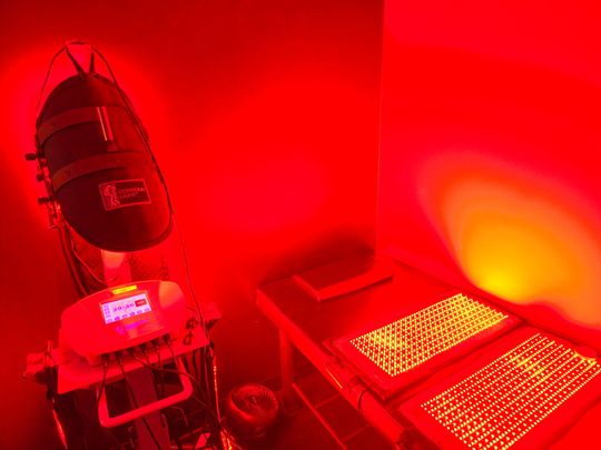 A room with red lights on the walls and a machine.