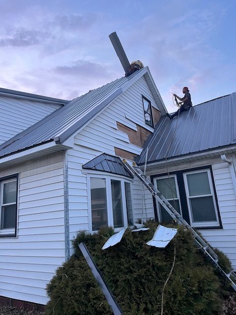 Woman in straw hat smiles, holding wine glass near a lake.
